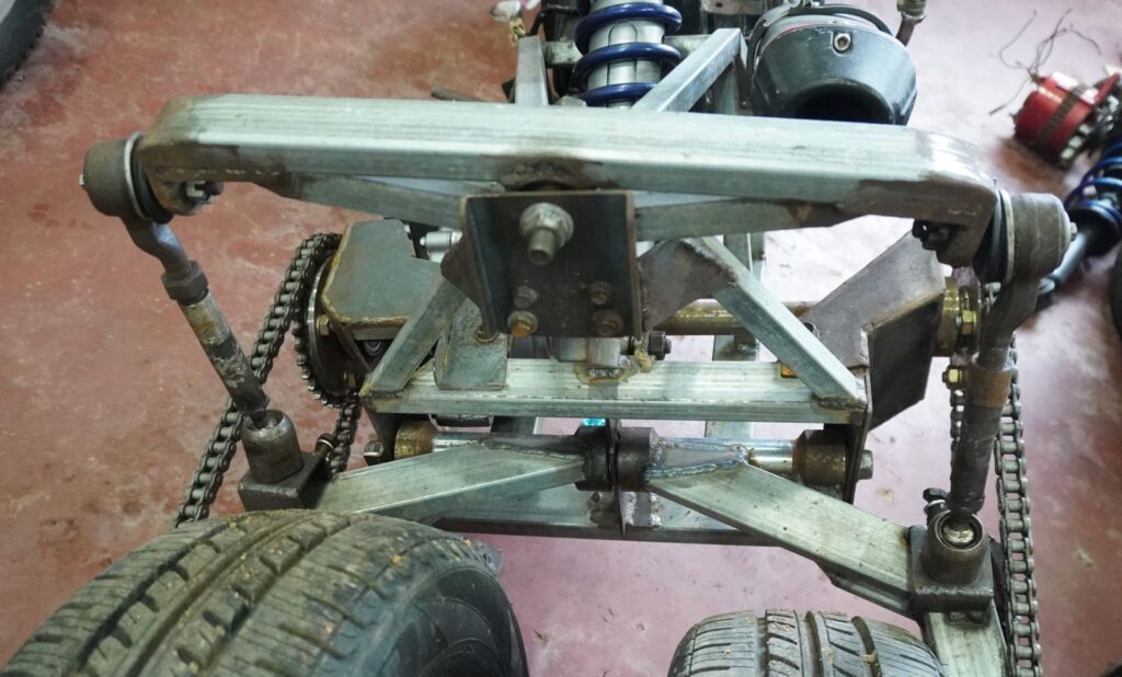 Custom rear linkage and wheel balancing system on a handmade tilting trike motorcycle