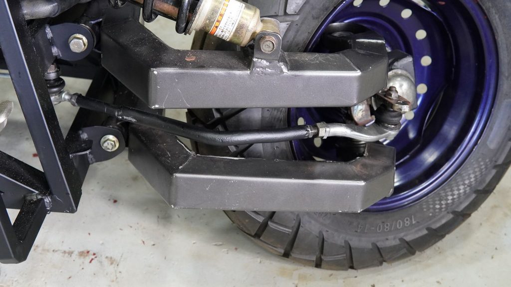 Custom front steering tie rod bar connecting the steering arms.
