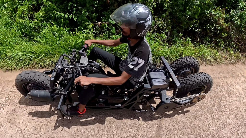 Kawasaki ER5 tilting trike being road tested, with the rider leaning the three-wheeled motorcycle into a turn.
